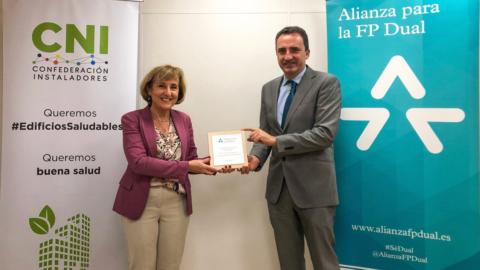 El senior project manager de la Fundación Bertelsmann en Madrid, Juan José Juárez, entrega la placa de adhesión a la Alianza por la FP Dual a Blanca Gómez, directora de la CNI.